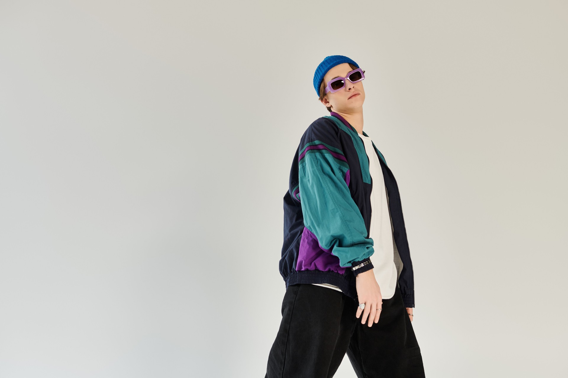 Young man in stylish bomber jacket showcases youth culture in modern studio